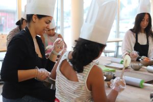 Mom smiling at daughters efforts at Mommy and Me class